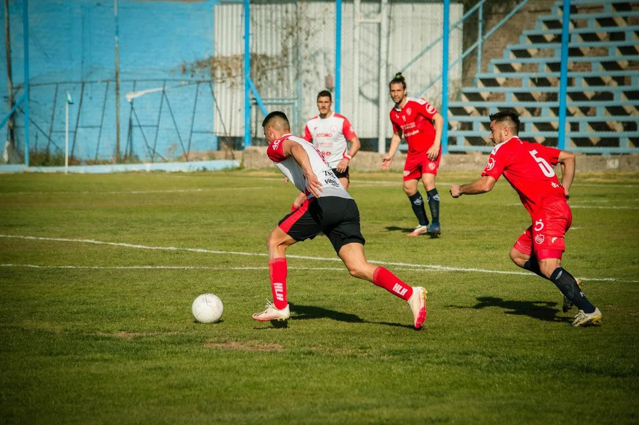 Fussballspieler in Aktion auf einem Spielfeld bei sonnigem Wetter