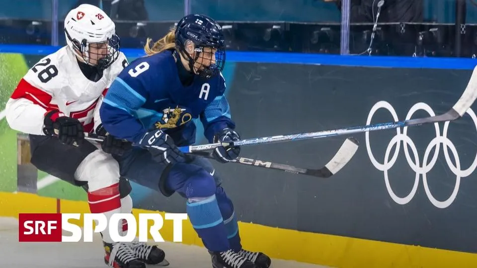 Zwei Eishockey-Spielerinnen kämpfen um den Puck nahe der Bande während eines olympischen Eishockey-Spiels