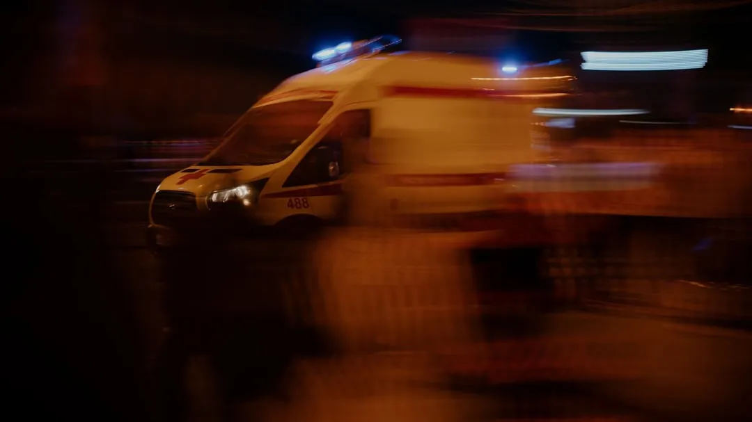 Weisser Rettungswagen bei nächtlichem Einsatz auf einer Strasse