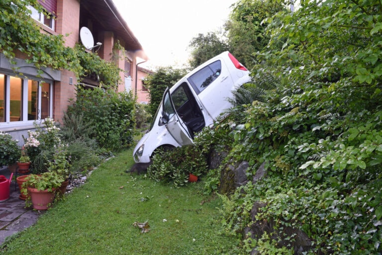 Auto rollt in steilem Gelände in einen Garten