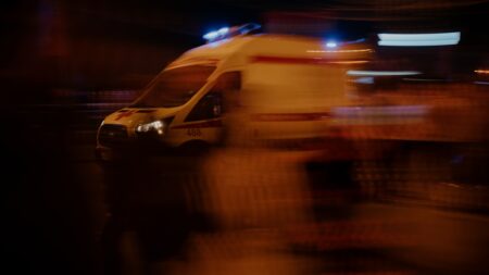 Weisser Rettungswagen bei nächtlichem Einsatz auf einer Strasse